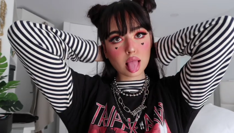 E-style — E-girl makeup, fringe and striped top — frame from Irisloveunicorns’ E-Girl Transformation video, 2019 — Irisloveunicorns- https://www.youtube.com/channel/UCy-Db59r86eTPEfOZ5LoWnQ — Wikimedia Commons / CC BY 3.0