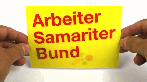 Lenticular Printing — Lenticular flip card, Arbeiter Samariter Bund / Bunt — preview of a photographed physical print; animated original at source — Raimond Spekking — Wikimedia Commons / CC BY-SA 4.0